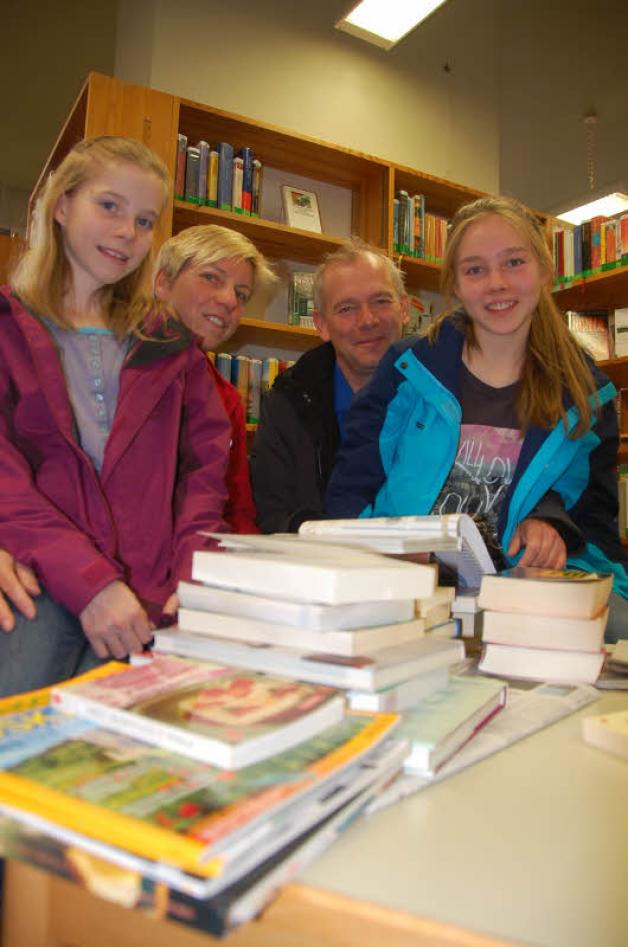 Familie Föllmer ist fündig geworden – Isabel (links) und Julia mit Mama Doris, Papa Thomas und ihrem Bücherstapel.  