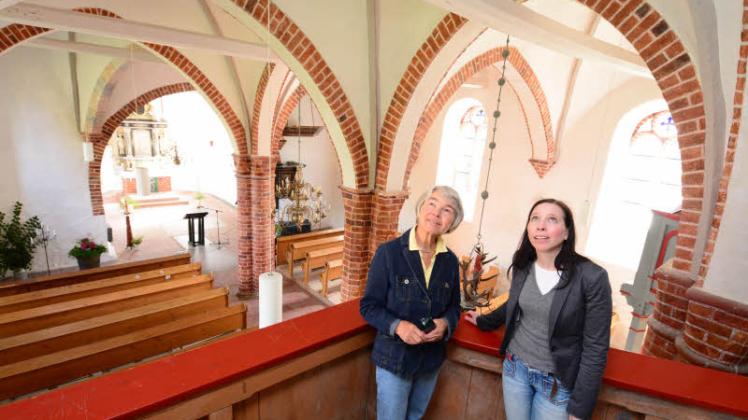 Carita Syed Ali und Pastorin Christina Stemmann (r.) freuen sich über das farblich aufgewertete Kirchenschiff. Der Wandanstrich konserviert Teile der alten Wandmalereien. 
