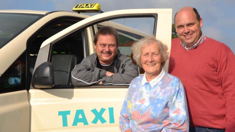 Gretchen Köhn ist der erste Fahrgast des Seniorentaxis. Christoph Arp, zweiter stellvertretender Bürgermeister (r.) begleitete sie zum Taxi, wo Fahrer Ralf Bukowski schon wartete. 