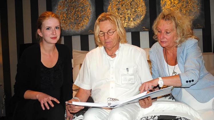 Karina (r.) und Frank-Dieter Klick sowie Azubi Maria Schlichting studieren einen Katalog.  