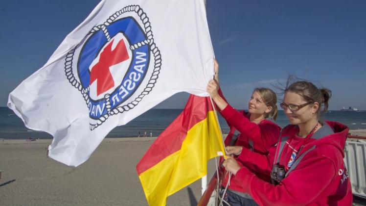 Die Rettungsschwimmerinnen Tina Blei (l.) und Klaudia Steinmar holen die Flagge am Hauptturm ein.  