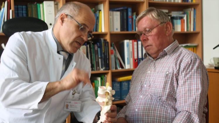 Prof. Wolfram Mittelmeier erklärt Patient Kurt Henning, wie sich dessen Rückenleiden auf seine Wirbelsäule auswirkt.  