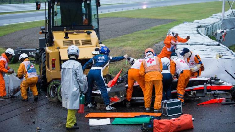 Streckenposten und Ärzte kümmern sich um den Formel-1-Fahrer Jules Bianchi vom Team Marussia F1 nach dem Crash beim Großen Preis von Japan.  