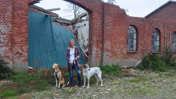 Ein Jahr Stillstand: Daniela Hahn mit ihren Hunden Leon und Momo vor der Ruine ihrer Therapiescheune in Esgrus. 