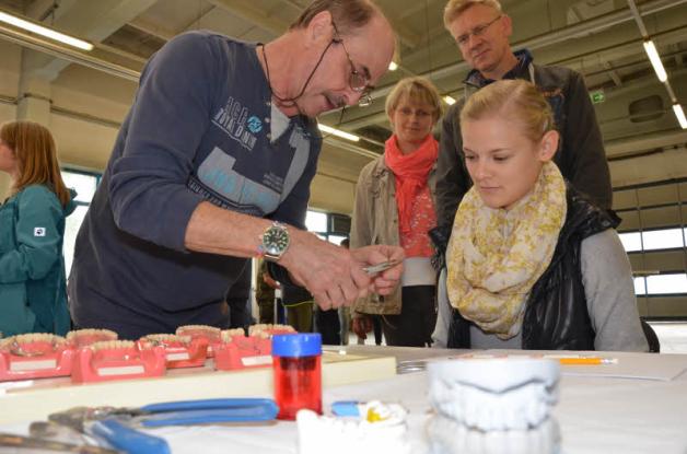 Zahntechniker Bernd Mathaus zeigt der Schülerin Hanna Schröder, wie sie einen Draht für Zahnspangen in Form bringt. 