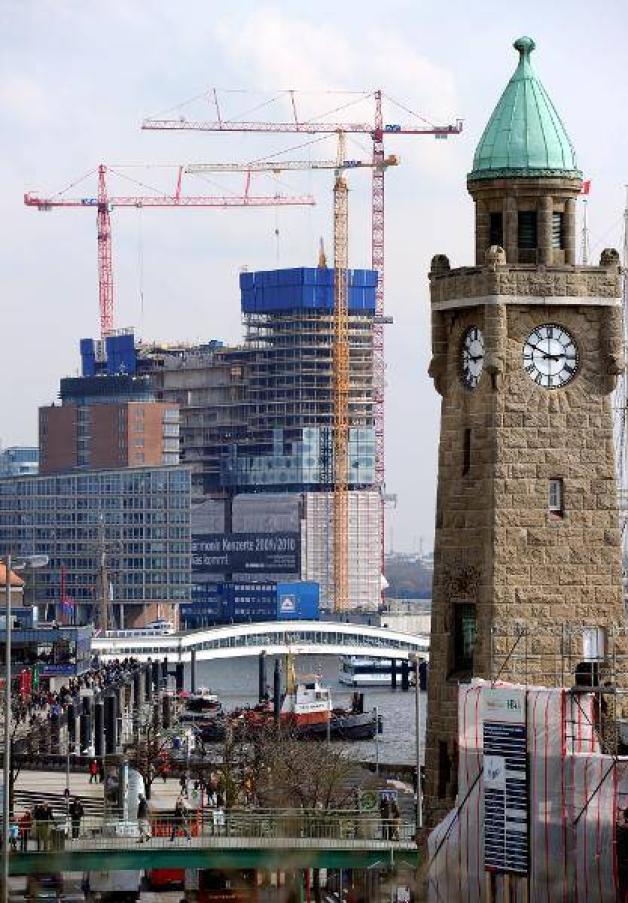 Die Baustelle der Elbphilharmonie ist neben dem Pegelturm der Landungsbrücken am im März 2010 in Hamburg zu sehen. Der von der SPD geforderte parlamentarische Untersuchungsausschuss wurde von der Hamburger Bürgerschaft einstimmig eingesetzt und nahm seine Arbeit auf. Foto: dpa