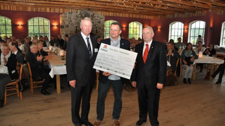 Björn Schwanke nimmt Geschenke an: Je 4000 Euro übergeben Wilfried Horn von der Lübzer Brauerei (l.) und Till Backhaus vom Land (r.) an die Stiftung. 