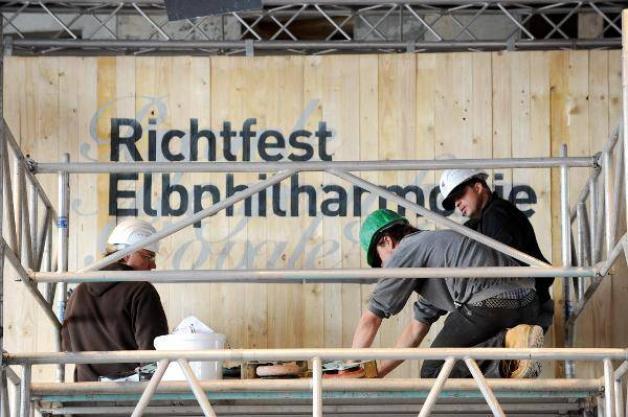 Im März 2010 bereiten Arbeiter auf der Baustelle der Elbphilharmonie das Richtfest vor. Das Event wurde von Protesten begleitet. Foto: dpa