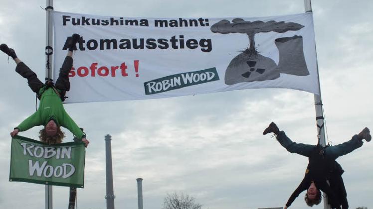  Robin-Wood-Aktivisten aus Hamburg hängten ihre Banner zwischen Fahnenmasten auf.  