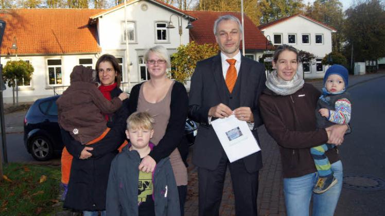 Protest gegen die Zentralschule: Sandy Peper mit Clara (6), Jennifer Moldenhauer mit Bent (5), Lutz Tschense und Mareike Müller mit Benno (1,5) wollen die Knüttel-Antonius-Schule (im Hintergrund) erhalten. 