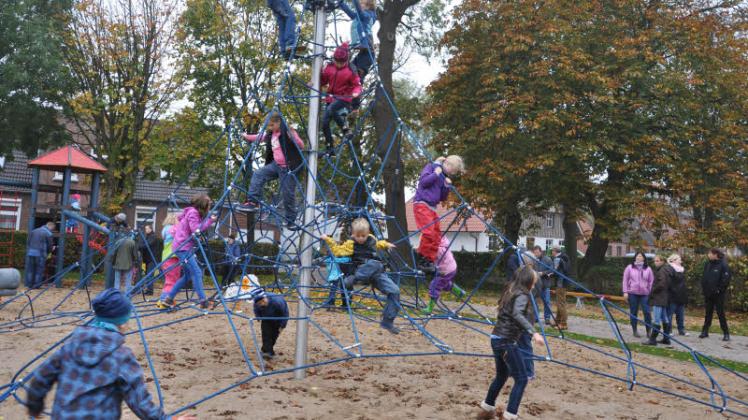 Die Kinder erklimmen das Seilnetz am Kletterturm des Mehrgenerationenplatzes. 
