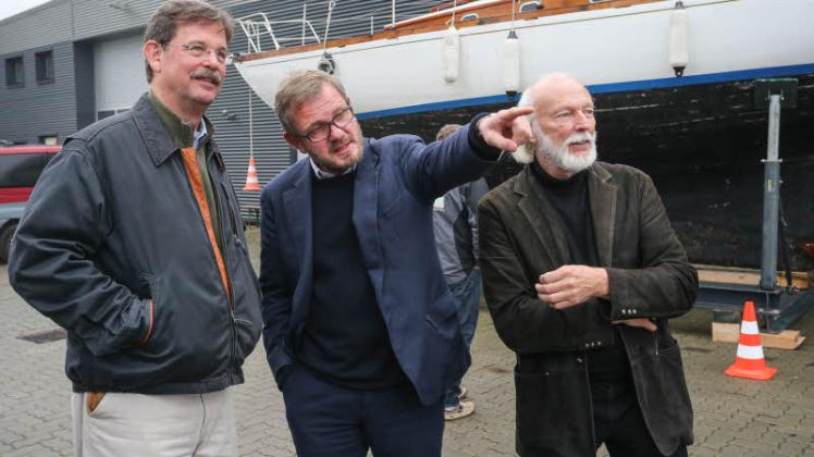 Und dahinten steht die schnelle Gretel! Oliver Berking (Mitte) führt Stephen White und Rainer Prüß (v.  l.) über das Gelände seiner Werft für klassische Yachten. 