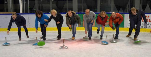 Sportliche Weihnachtsfeier: Acht Mitarbeiter der Sparkasse Westholstein aus Itzehoe beim Eisstockspielen zur Disco-Musik. 