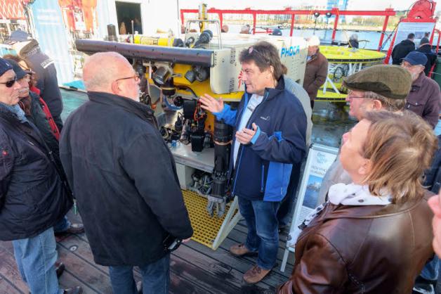 Dr. Gerd Hoffmann-Wieck (r.) vom Geormar-Helmholtz-Zentrum erläutert Besuchern das ferngesteuerte Unterwasserfahrzeug „ROV PHoca“.  