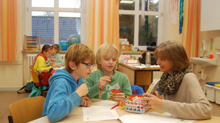 Energie für den Kopf: Lehrerin Gudrun Stücker verteilt an die neunjährigen Schüler Hannes Treeck und Johann Schack (v.r.) Süßigkeiten.  