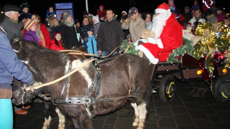 Ponys statt Rentiere: In seiner Kutsche fuhr der Nikolaus – umringt von zahlreichen Kindern mit ihren Eltern und Großeltern vom Hafen zum Weihnachtsmarkt, wo er Geschenke für aufgesagte Gedichte verteilte. 
