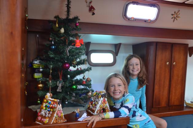 Weihnachtsbäume gibt es auch in Chile zu kaufen. Und mit der Post kommen Pfefferkuchen-Häuschen aus Deutschland aufs Boot. Maya und Lena basteln sie zusammen. 