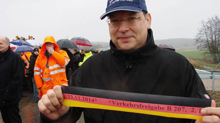 Reinhard Meyer (SPD), Schleswig-Holsteins Verkehrsminister, hält ein Stück Zeitgeschiochte in Hände: Die B 207 neu zwischen Lübeck und Pogeez konnte nun doch freigegeben werden. 