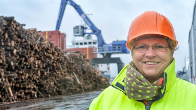 Daniele Priebe, Chefin des Rostocker Fracht- und Fischereihafens, blickt trotz Herausforderungen optimistisch in die Zukunft, während hinter ihr Holz aus dem Baltikum für Stendal umgeschlagen wird. 
