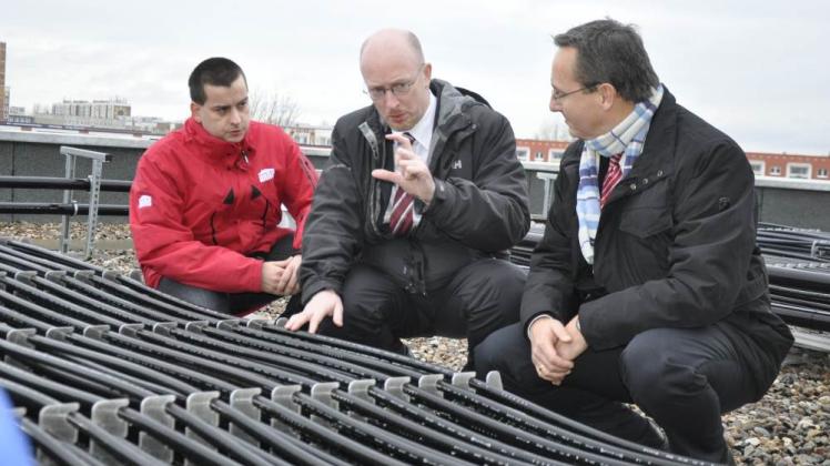 Auf dem Dach des Wohnkomplexes ließ sich Energieminister Christian Pegel (SPD, M.) den Eisspeicher von Stephan Strobel (l.) und Christian Urban von der Wiro erklären.  