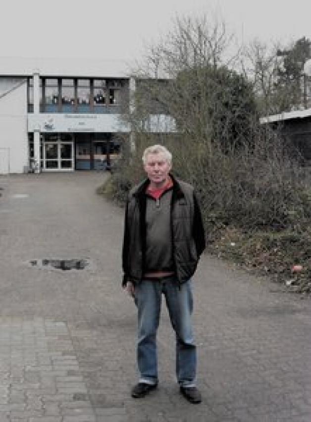 Norbert Retelsdorf vor seinem Arbeitsplatz - er ist Hausmeister und Platzwart für Schule und Sportplatz am Lübecker Koggenweg.