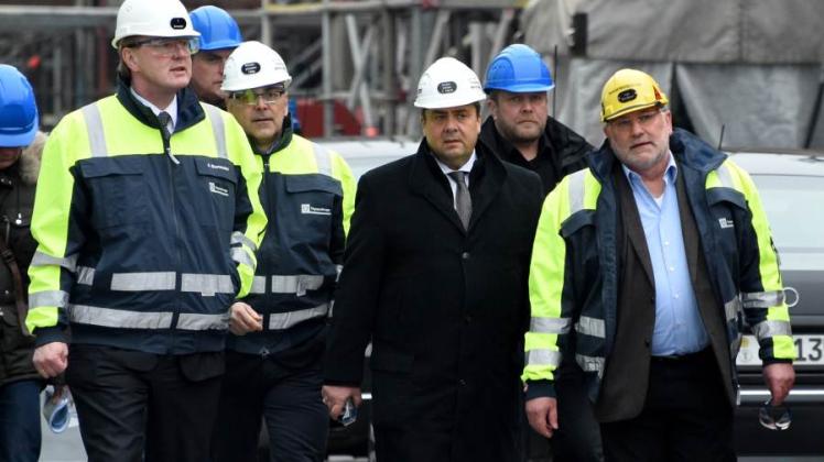 Wirtschaftsminister Sigmar Gabriel (M) geht mit Betriebsratschef Ernst-August Kiel (r.) sowie dem Vorstandschef Andreas Burmester (l.) und Ministerpräsident Torsten Albig (2.v.l.) über das Gelände der ThyssenKrupp Werft. 