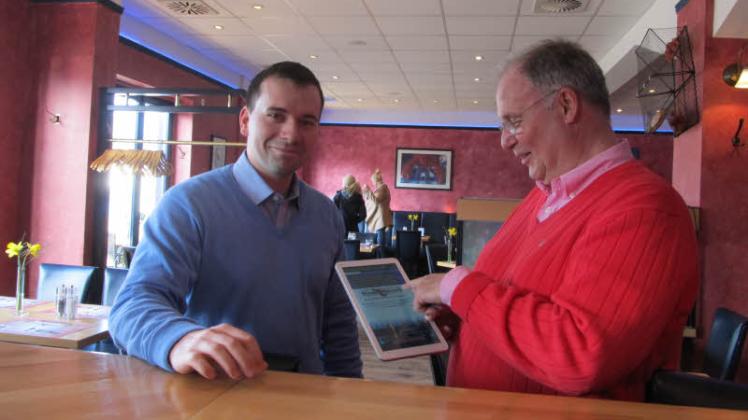 Restaurantleiter Marcus Schneider und Hummerkorb-Chef Kurt Weber (r.) testen die Handhabung der digitalen Speisekarte.  