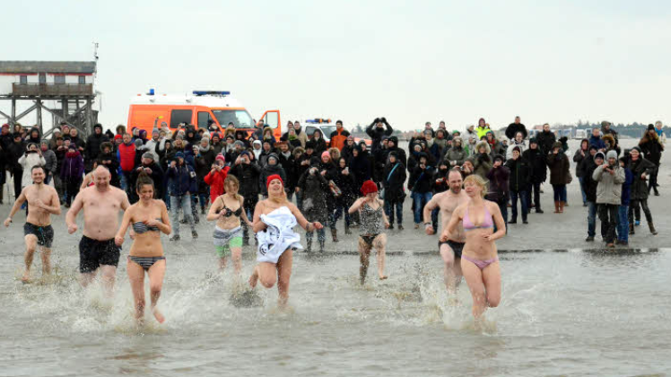 Mit Karacho ging es ins Wasser, während die Zuschauer gut eingepackt am Strand standen.  