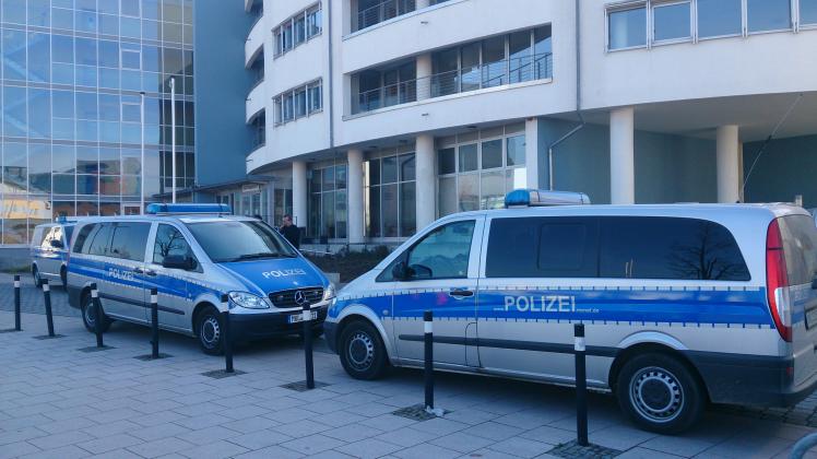 Bombendrohung im Landgericht Rostock. Polizeifahrzeuge vor dem Eingang.