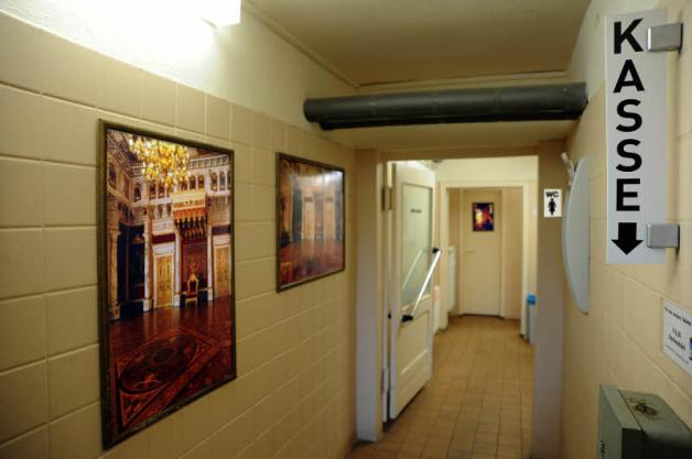 Fotografien des Thronsaals aus dem Schweriner Schloss zieren die Wände der öffentlichen Toilette .  