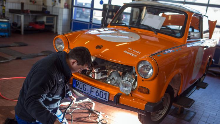 Neue Kabelbäume für das Umrüsten auf Elektroantrieb montiert Mechaniker Martin Köchele in einer Autowerkstatt in Schwerin im Motorraum eines Trabant.