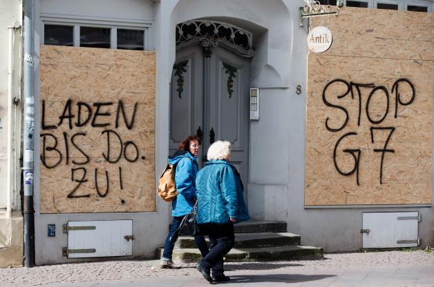 Spanplatten mit den Aufschriften „Stop G7“ und „Laden bis Do. zu!“ sind auf den Schaufenstern eines Geschäfts in der Innenstadt zu sehen. Spanplatten mit den Aufschriften „Stop G7“ und „Laden bis Do. zu!“ sind auf den Schaufenstern eines Geschäfts in der Innenstadt zu sehen.