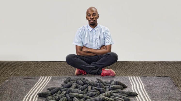 Setlamorago Mashilo vor seiner Skulptur: 500 Maiskolben liegen auf einer Decke und symbolisieren den ungerechten Kampf um Land in Südafrika... 