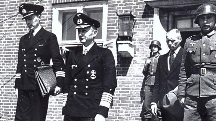 Eines der wenigen Fotos der Regierung Dönitz: Großadmiral Karl Dönitz (Mitte) und sein Adjutant Walter Lüdde-Neurath verlassen ihren „Regierungssitz“ in der Mürwiker Marinesportschule am 11. Mai 1945. 