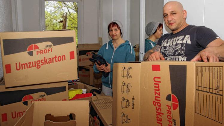 Juliane Gummel und Marcel Berlt packen in Moisall Kisten mit ihrem Hab und Gut aus.  
