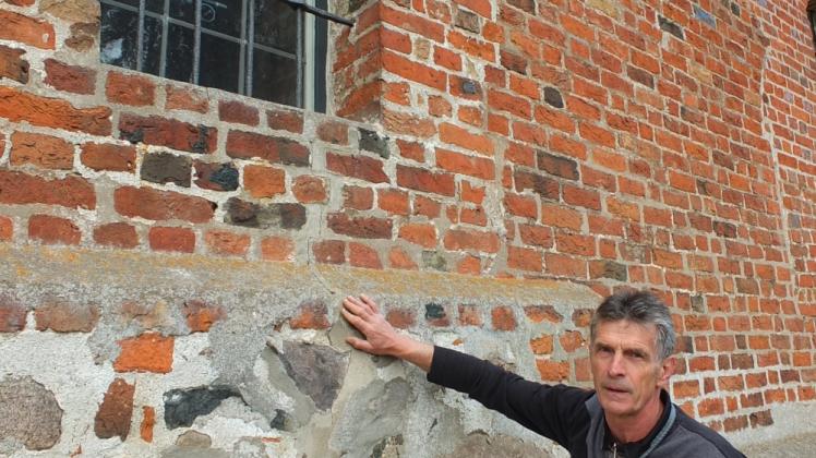 Pastor Erhard Graf zeigt, wo der neue Riss durch das Kirchenfenster verläuft. 