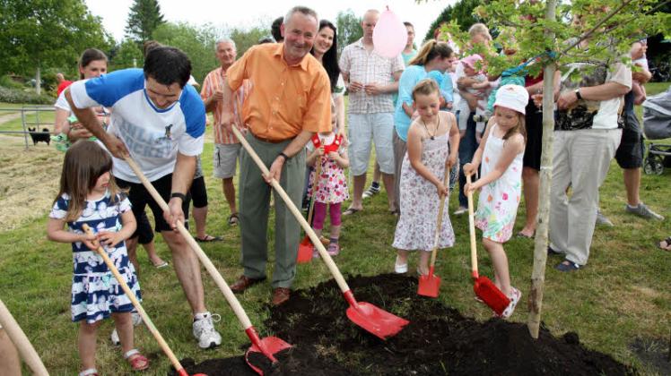 Für den Jahrgang 2014/15 wird traditionell ein Baum im Park gepflanzt. So begrüßen Bürgermeister Joachim Hünecke (3. v. l.) und die Gemeinde ihre jüngsten Einwohner.  