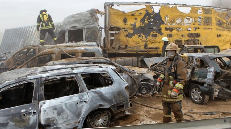 Feuerwehrleute sind am 8. April 2011 auf der Autobahn A19 bei Kavelstorf bei einer Massenkarambolage im Einsatz. Ein Sandsturm hatte zu dem schweren Unfall geführt.  