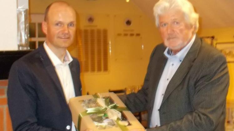 Ein Dankeschön: Der neue Präsident des Golfclubs Oldenburger Land, Uwe de Vries (rechts), überreichte seinem Vorgänger Roman Szemetat ein Präsent für dessen zehnjähriges Engagement. 