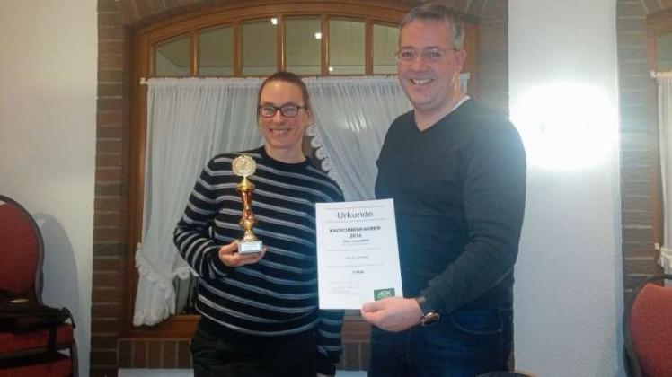 Geehrt: Ose Lenderts erhielt vom neuen Vorsitzenden Axel Mehrtens eine Urkunde plus Pokal für ihre Leistungen im Bereich der Radtourenfahrten. 