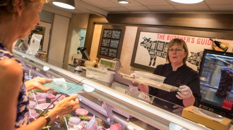 Mit der eigenen Frischhaltedose kauft Margret Hawighorst im Markant-Markt Rulle Käse. Möglicht macht dies ein sogenanntes Hygienetablett, das Verkäuferin Christiane Abdou über die Theke hält. Foto: Swaantje Hehmann
