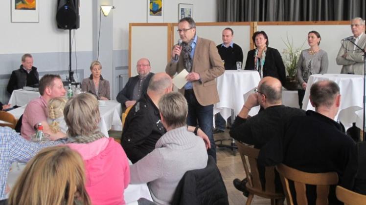 Mit den Vertretern der Parteien im Rücken: Bürgermeisterkandidat Helmut Knurbein stellt sich den Besuchern im Meppener Kolpinghaus vor. 