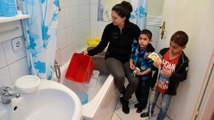 Der Wasservorrat ist schon wieder aufgebraucht: Mieterin Elke Akyol mit ihren Kindern Merdan (4) und Ali Can (7) im Badezimmer ihrer Mietwohnung. 