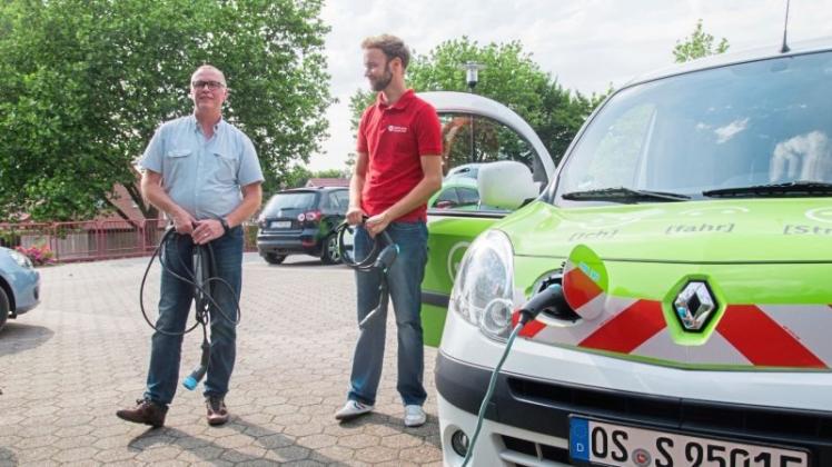 Michael Piel und Tobias Ahlering stellen ein Elektroauto der Stadt Osnabrück vor. 