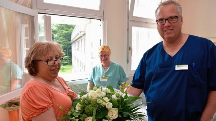 Blumen für Patientin Ria Reschke (links). An ihr haben Chefarzt Dr. Dirk Meyer und Operationsschwester Anja Schneider den 1000. operativen Eingriff in der Abteilung für Wirbelsäulen- und spinale Neurochirurgie am Josef-Hospital Delmenhorst vorgenommen. 