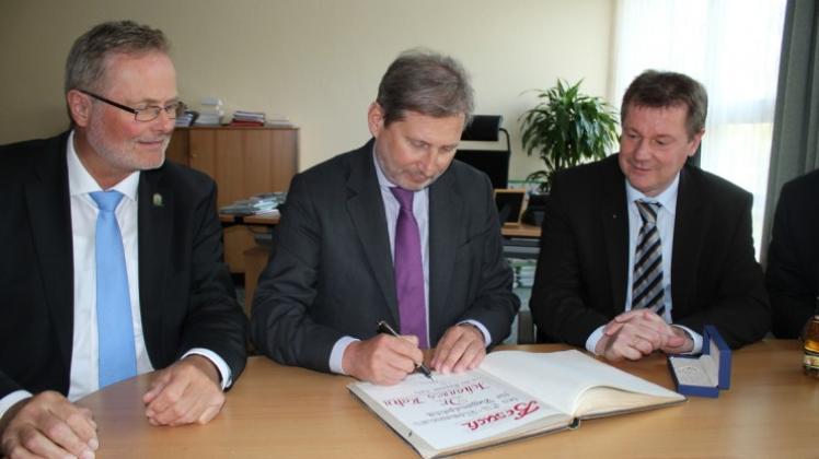 Beim Eintrag ins Goldene Buch assistiert (von links) Bürgermeister Rainer Lammers EU-Kommissar Johannes Hahn; und Gastgeber Markus Pieper schaut zu.
