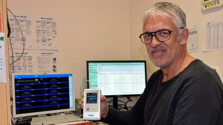 Jörg Poggensee, Medizintechniker im JHD, zeigt die kleine Apparatur, die der Patient am Körper trägt. Sie gibt über ein W-Lan Daten weiter, die direkt auf dem Monitor zu sehen sind – und schlägt im Notfall Alarm. 