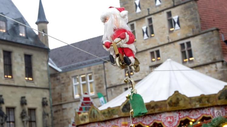 Mit einem goldenen Fahrrad saust der kleine Nikolaus auf dem Osnabrücker Weihnachtsmarkt auf diesem Seil hin und her. Foto: Jörn Martens