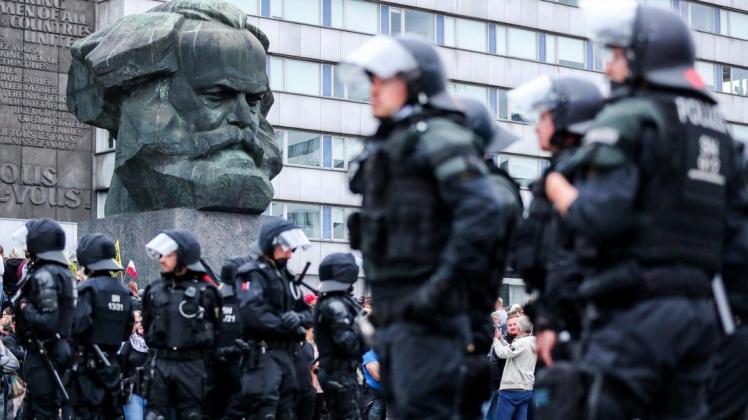 Demonstrationen - wie hier vor dem Karl-Marx-Denkmal in Chemnitz - binden regelmäßig viele Polizeikräfte und sorgen für Überstunden bei der Polizei. Foto: Jan Woitas/dpa