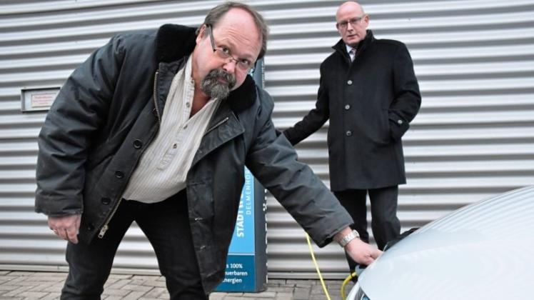 Dr. Florian Spiggelkötter (links), Besitzer eines Elektroautos, nimmt gemeinsam mit Geschäftsführer Andreas Weber die neue E-Ladesäule in Betrieb. 